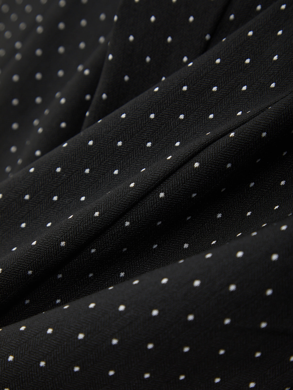 Close-up of black fabric with white polka dots