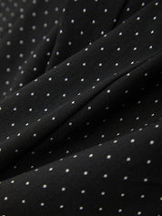 Close-up of black fabric with white polka dots