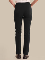Person wearing black pants on a beige background