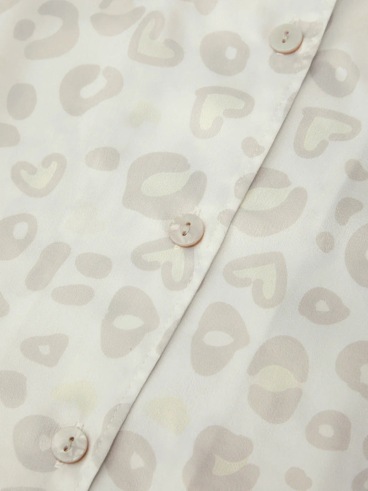 Close-up of a shirt with leopard pattern and buttons on a light background