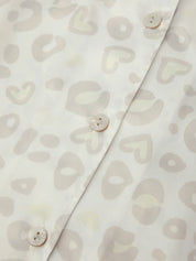 Close-up of a shirt with leopard pattern and buttons on a light background