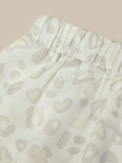 Close-up of a white garment with a subtle pattern on a beige background