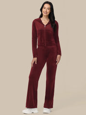 Woman wearing a burgundy tracksuit on a beige background
