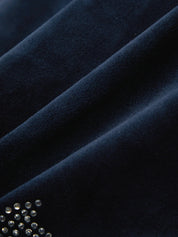 Close-up of dark blue fabric with a small embellishment of crystals.