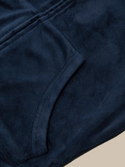 Close-up of dark blue fabric with a pocket on a beige background