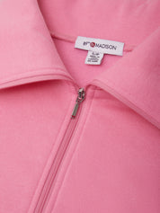Close-up of a pink zip-up jacket with a collar, showing a white interior neck label that reads 89th & MADISON.