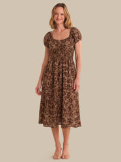 Woman wearing a brown leopard print dress against a beige background