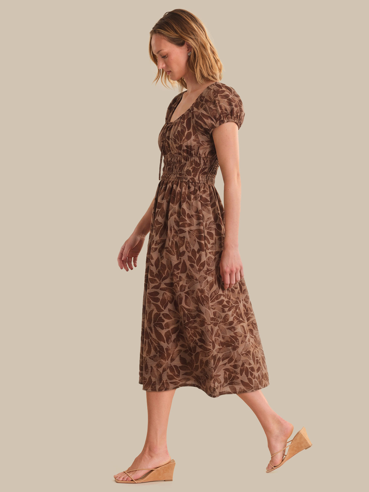 Woman wearing a leopard print dress on a beige background