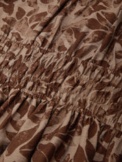 Close-up of brown and beige patterned fabric with a ruffled edge.