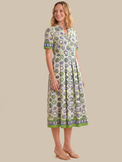 Woman wearing a patterned dress on a beige background
