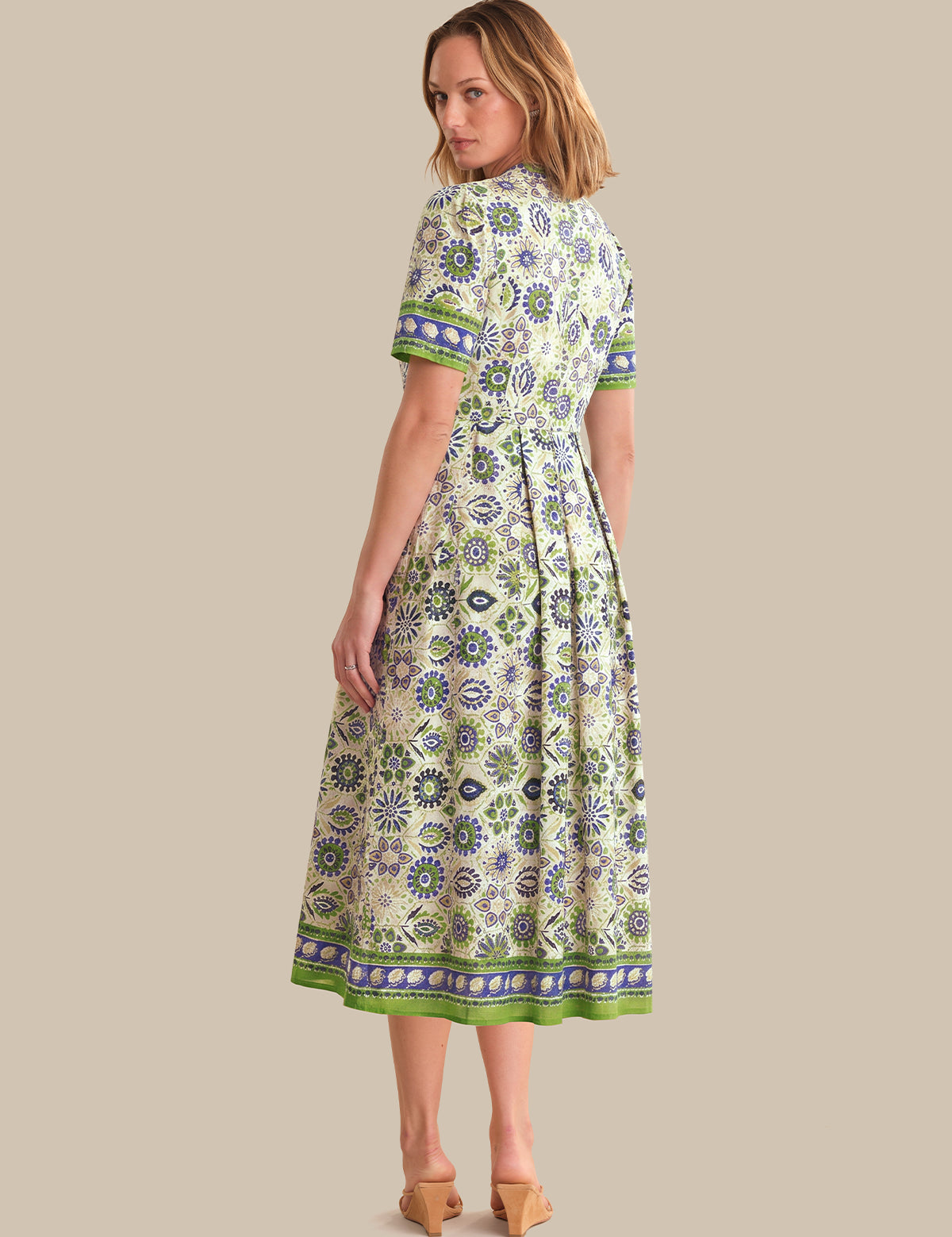 Woman wearing a patterned dress on a beige background