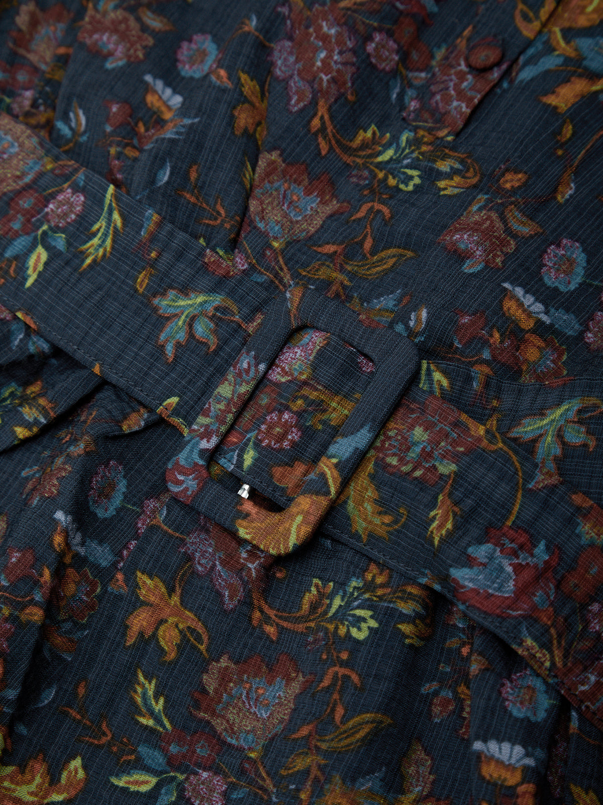 Floral patterned fabric with a button detail on a dark background