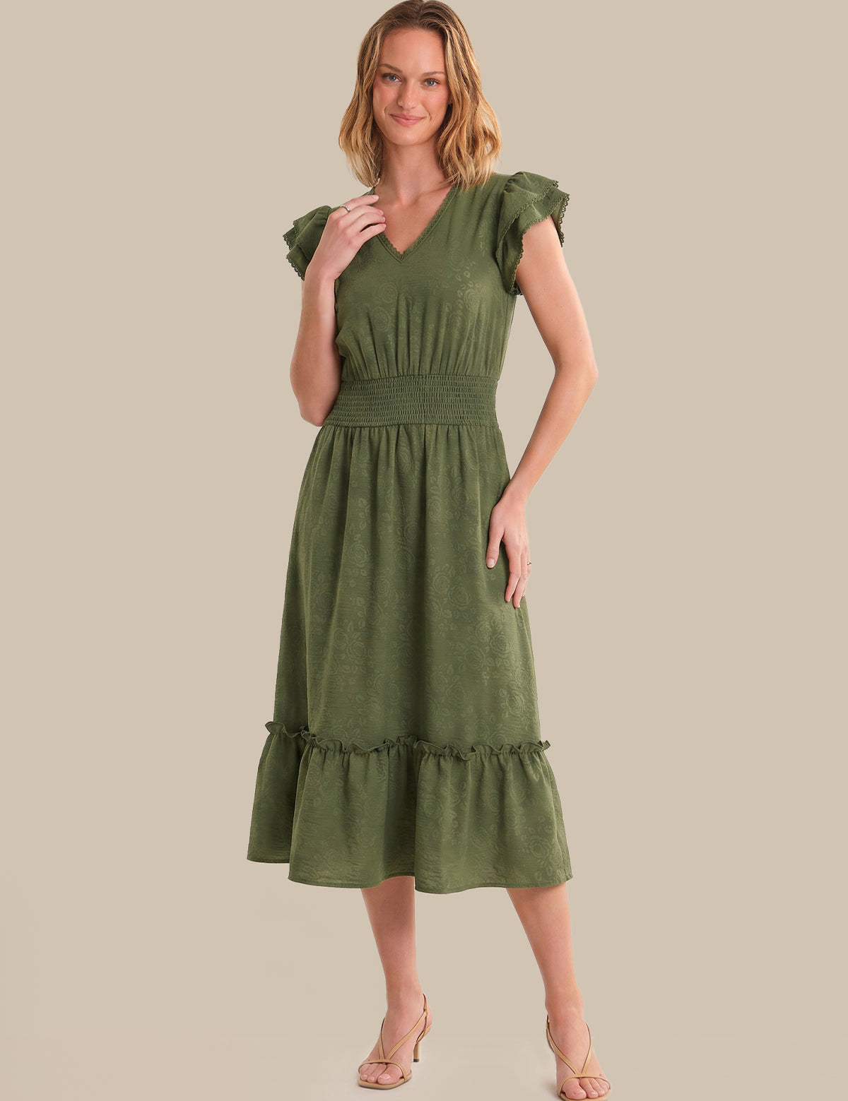 Woman wearing a green dress against a beige background
