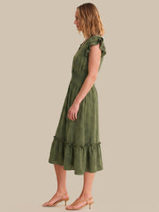 Woman wearing a green dress against a beige background