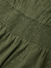 Close-up of green fabric with floral pattern and gathered waistband