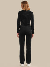 Person wearing a black tracksuit on a beige background