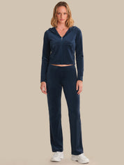 Woman wearing a navy blue tracksuit on a beige background