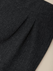 Close-up of dark charcoal gray pleated fabric, showing the fine woven texture and fold details.