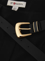 Close-up of a black belt with a polished gold buckle and gold stripe detailing, laid over a black garment. The brand label '89th Madison' is visible at the collar.