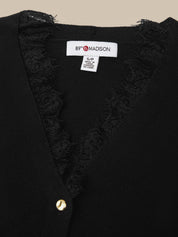 Close-up of a black knit cardigan with a V-neck and frayed lace trim, featuring a white interior neck label that reads 89° MADISON.