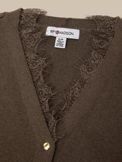 Close-up of a brown knit cardigan with a V-neck and floral lace trim, showing the interior neck label that reads 89° MADISON.