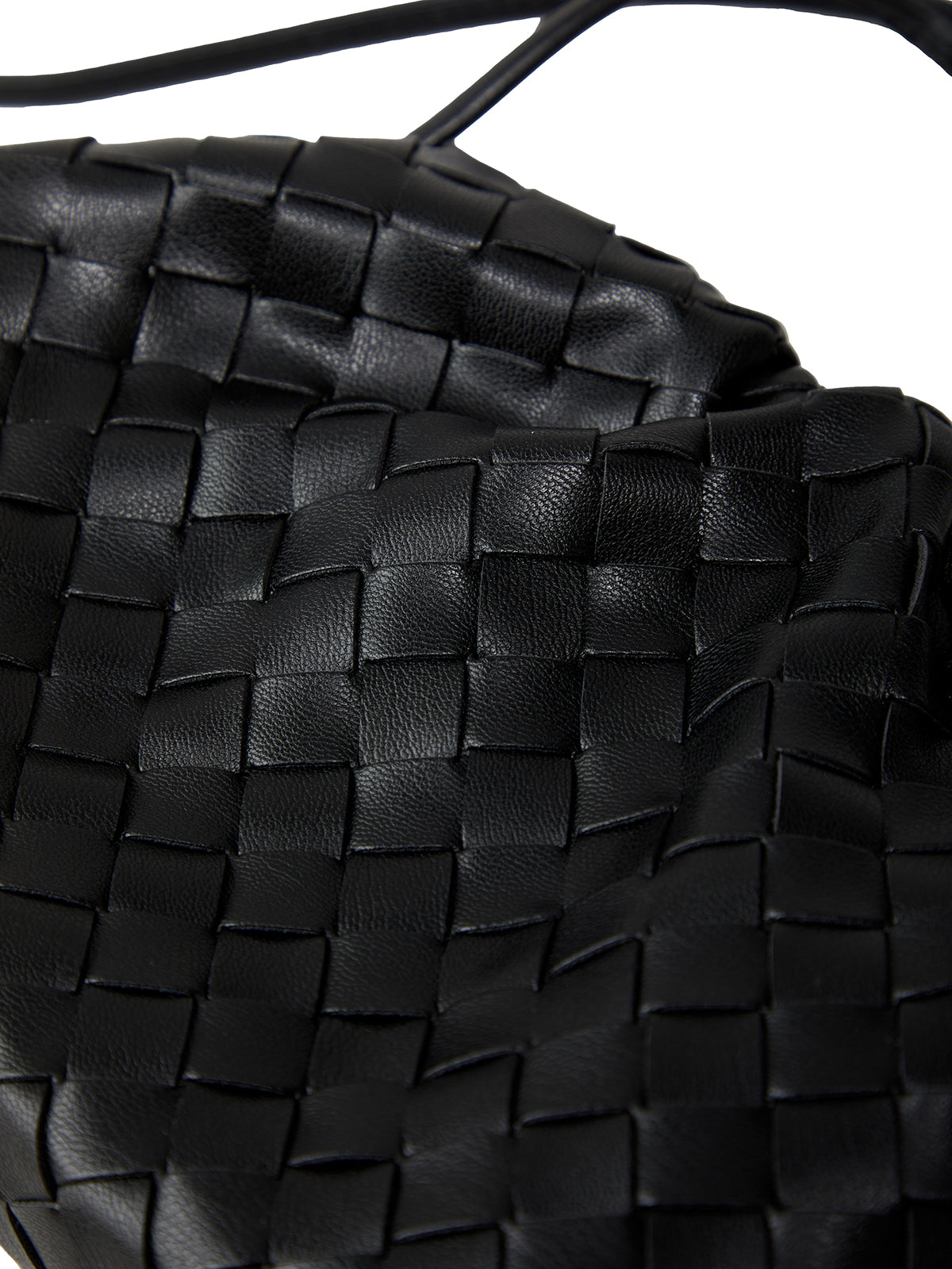 Close-up of a black woven handbag with a strap.