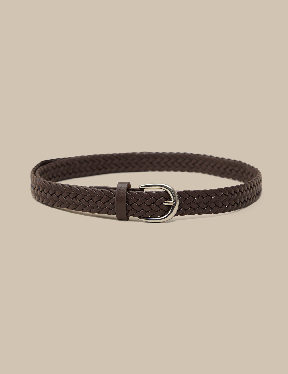 Brown braided belt with a silver buckle on a beige background