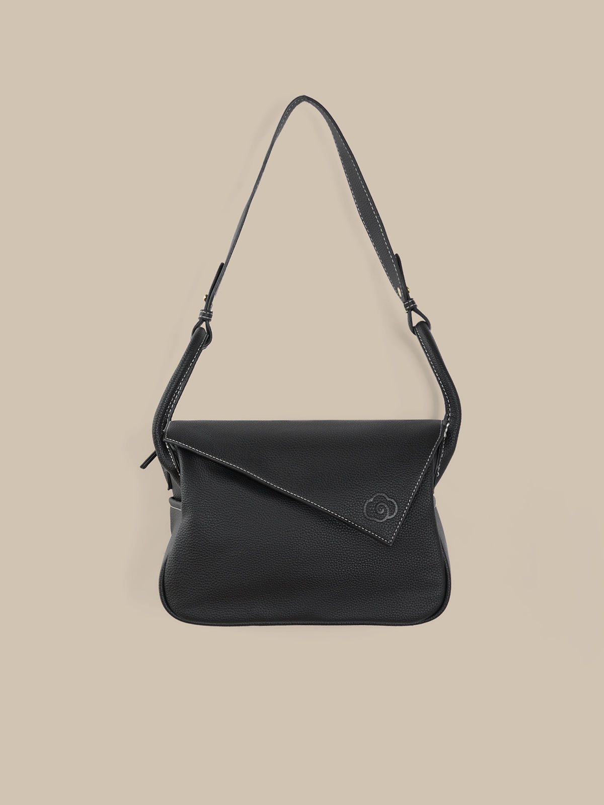 Black shoulder bag on a beige background