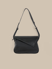 Black shoulder bag on a beige background