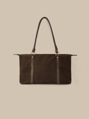 Brown handbag with black straps on a beige background