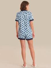 Woman wearing a blue floral pajama set on a beige background