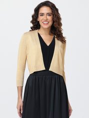 Woman wearing a beige cardigan over a black dress on a white background