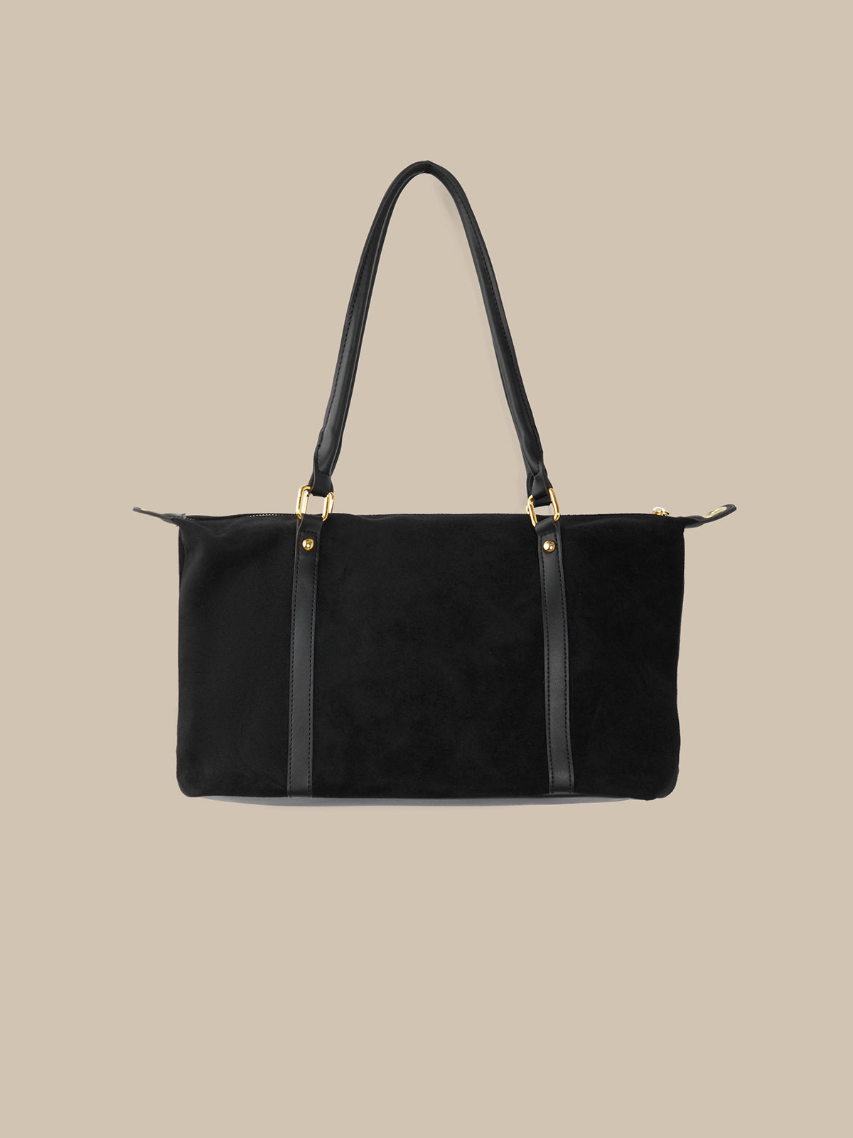 Black handbag with gold hardware on a beige background