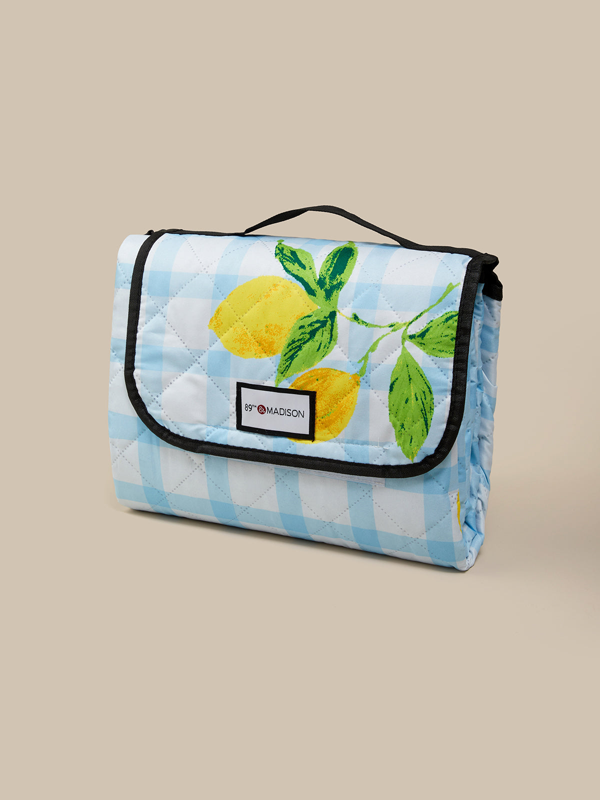 Foldable picnic blanket with lemon design on a beige background