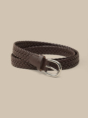 Brown braided belt with a silver buckle on a beige background
