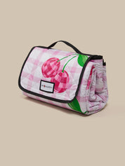 Pink quilted bag with cherry design on a beige background