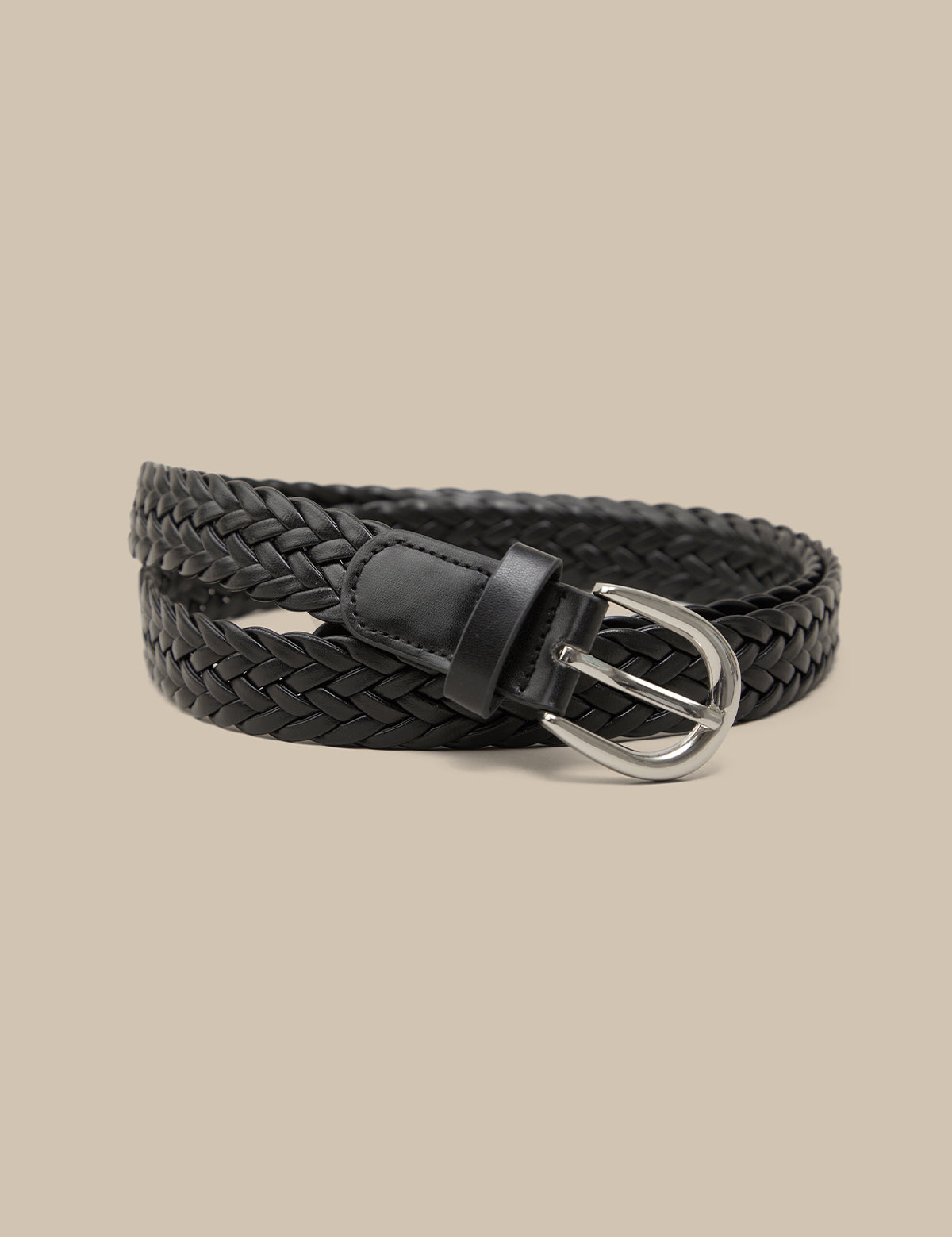 Black braided belt with a silver buckle on a beige background