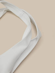 Light white fabric strap on a beige background