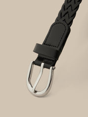Black braided belt with silver buckle on a beige background