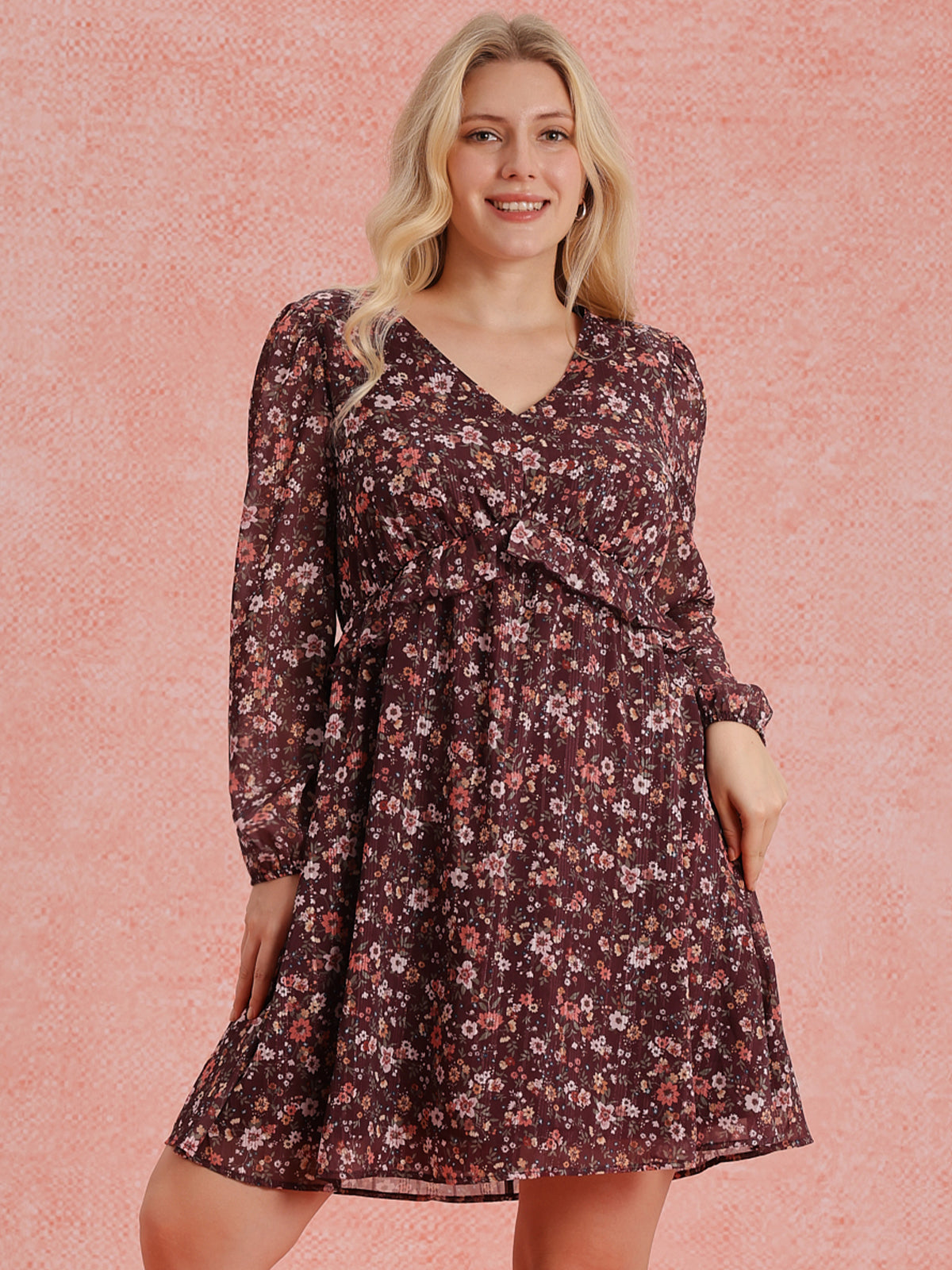 Woman wearing a floral dress against a pink background