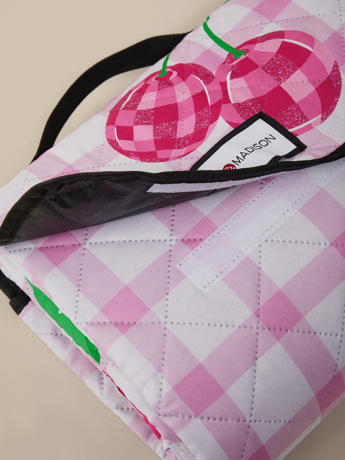Pink and white checkered bag with cherry design and Maison label.