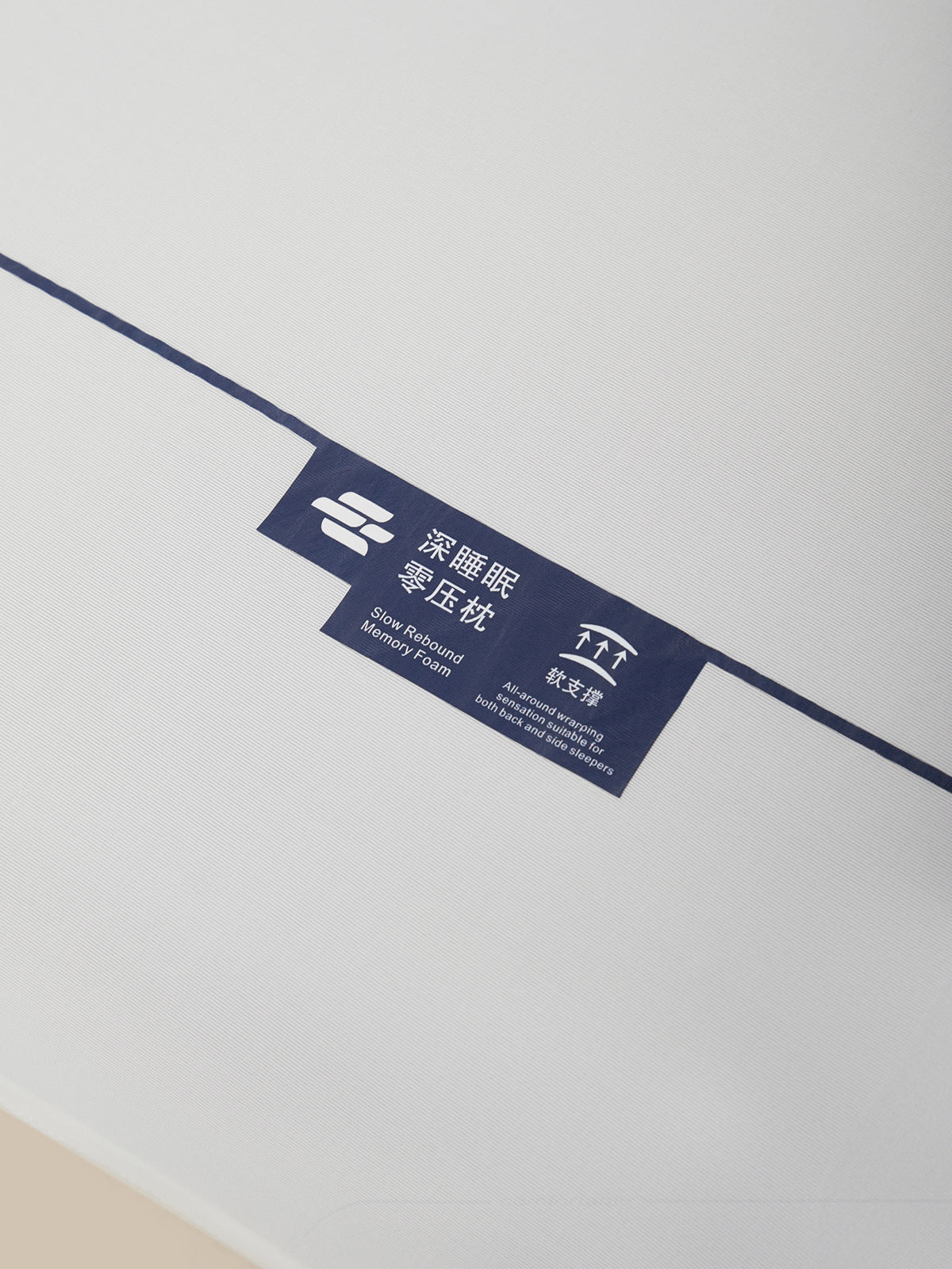 A close-up of a dark blue product label with white text and logos, attached to a thin dark blue line on a plain white background.