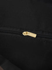 Close-up of a black zipper with a gold pull on a black background