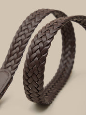 Brown braided leather belt on a beige background