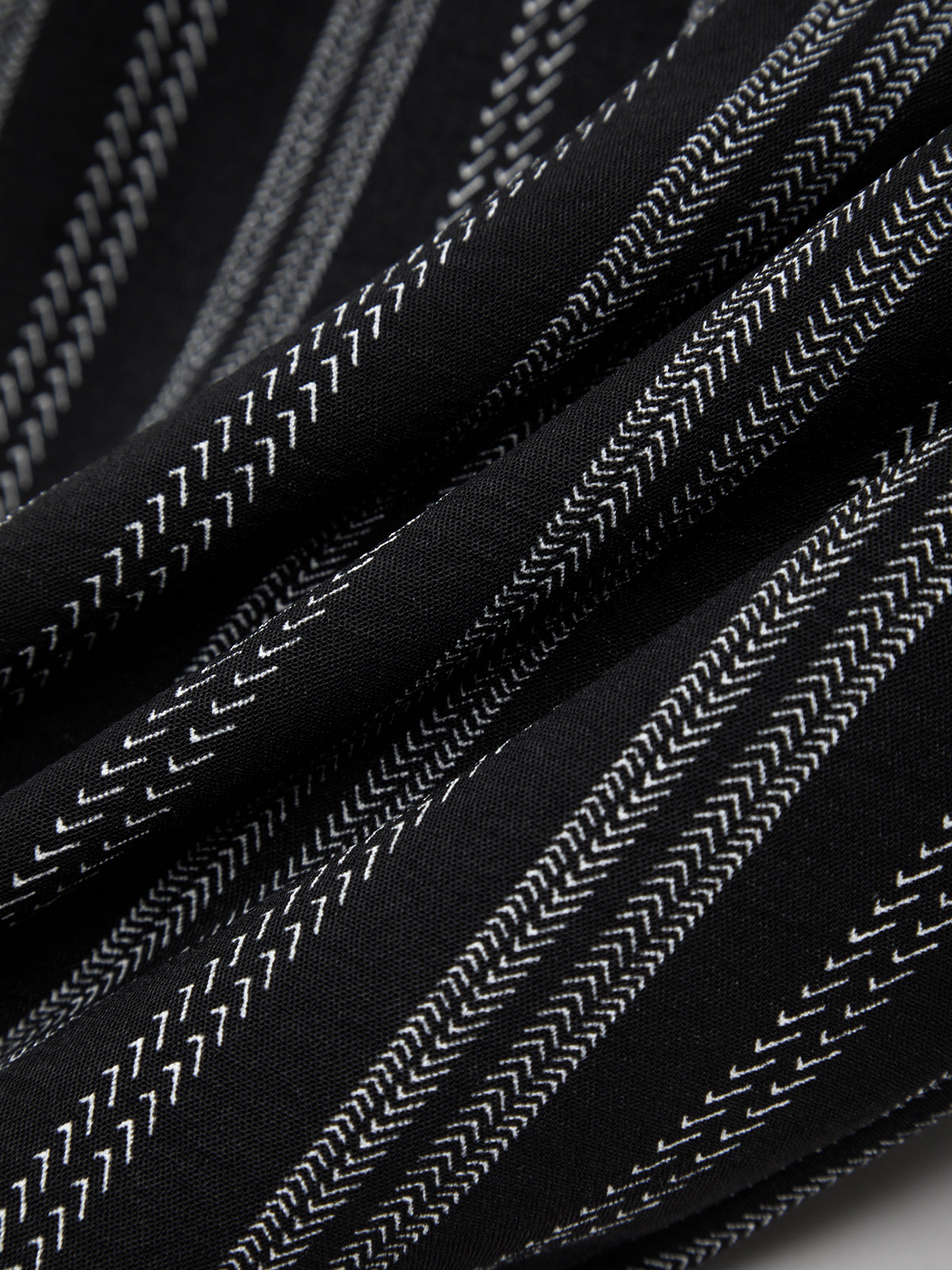 Close-up of black fabric with white stitching pattern