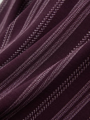 Close-up of a textured maroon and white fabric with white stitching details