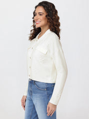 Woman wearing a white cardigan and blue jeans on a white background
