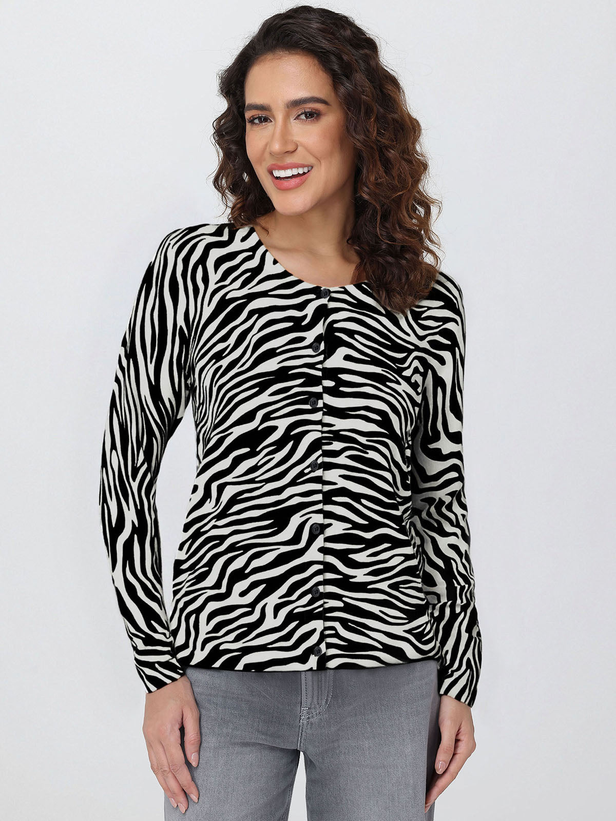 Woman wearing a zebra print cardigan against a plain background