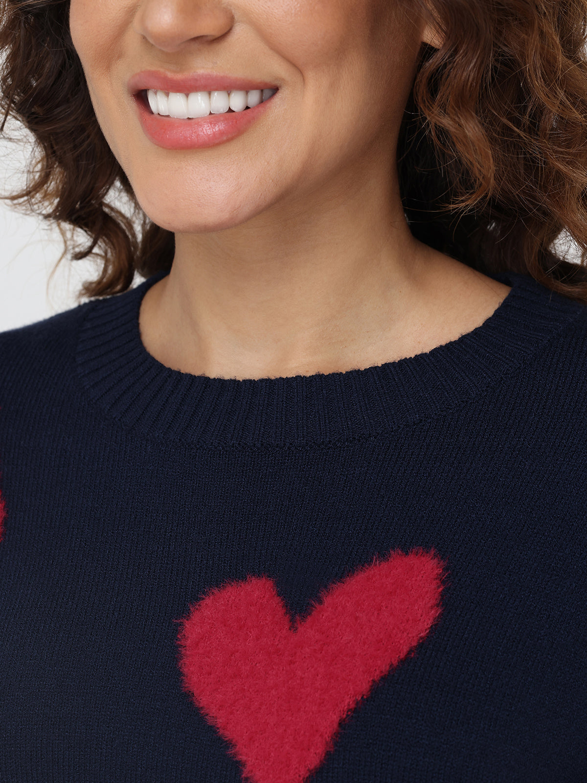 Navy sweater with a red heart design worn by a person.