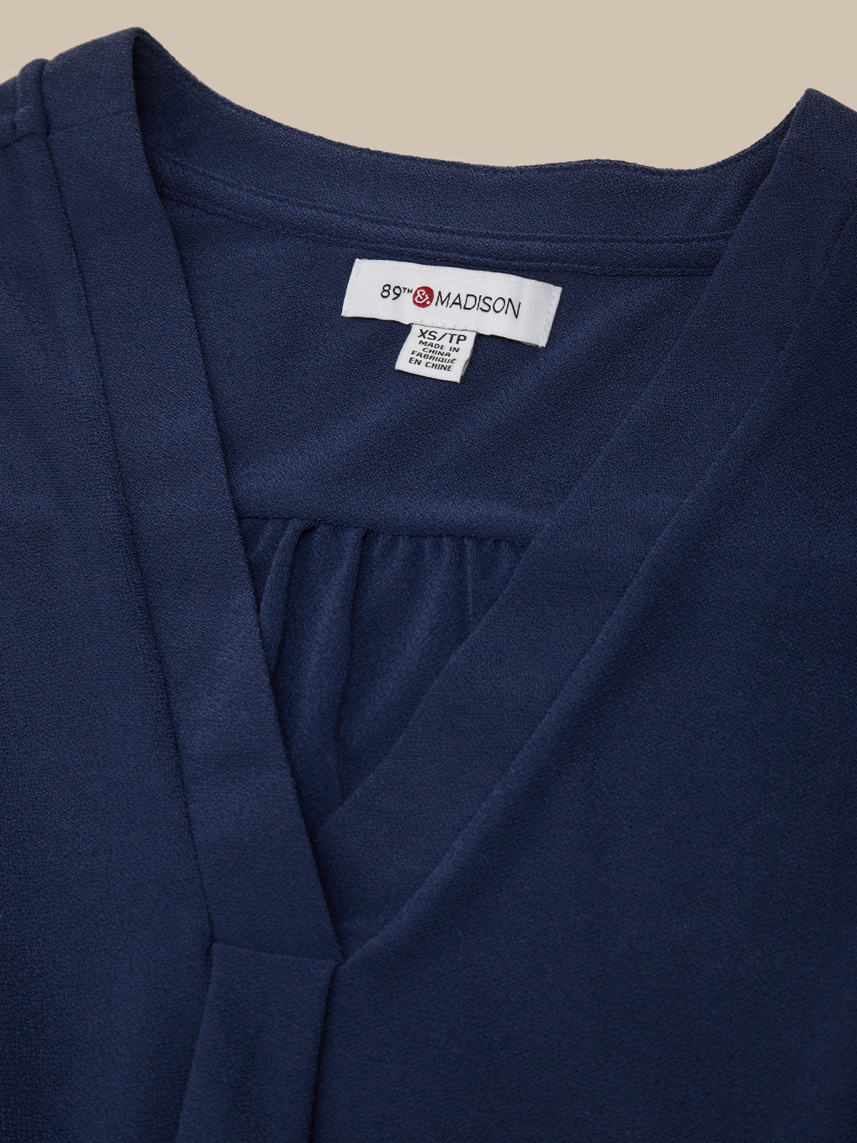 Navy blue garment with a brand label on a beige background